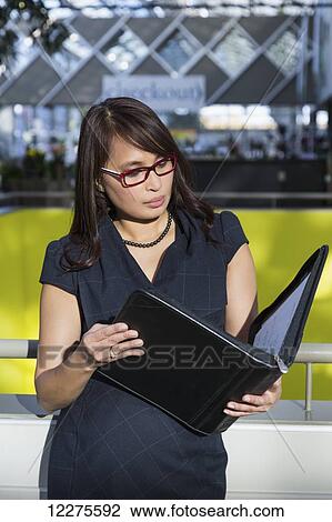 Stock Image - Professional businesswoman with a portfolio in a shopping centre; St. Albert, Alberta, Canada. Fotosearch
