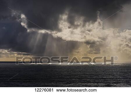 Stock Image - Rain falls in the distance off the coast; Oregon, United States of America. Fotosearch