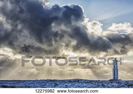 Rays of light shine out from behind the clouds in the skies above a lighthouse along the southern shore of Iceland; Iceland View Large Photo Image Stock Image - Rays of light shine out from behind the clouds in the skies above a lighthouse along the southern shore of Iceland; Iceland. Fotosearch
