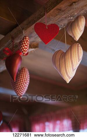 Red heart decorations in felt, fabric and metal hanging from a wooden ceiling beam; Filzmoos, Austria View Large Photo Image Stock Image - Red heart decorations in felt, fabric and metal hanging from a wooden ceiling beam; Filzmoos, Austria. Fotosearch