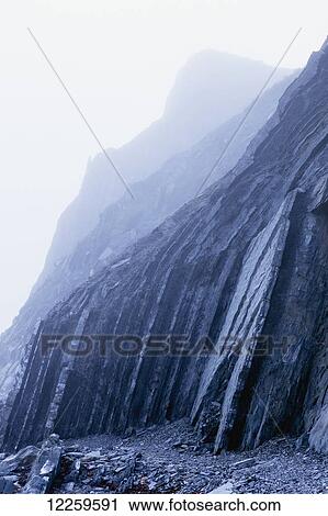 Stock Image - Rock cliff in the fog; Perce, Gaspesie, Quebec, Canada. Fotosearch