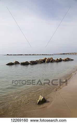 Stock Image - Rocks in the water off the beach; Peyia, Paphos, Cyprus. Fotosearch