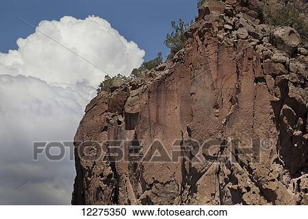 Rocky cliff with vegetation on top and billowing clouds in the background; New Mexico, United States of America View Large Photo Image Stock Image - Rocky cliff with vegetation on top and billowing clouds in the background; New Mexico, United States of America. Fotosearch