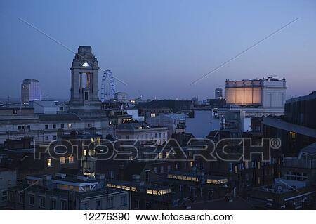 Stock Image - Rooftops of Covent Garden seen from Newton Street, with the London Eye and the Freemasons' Hall; London, England. Fotosearch