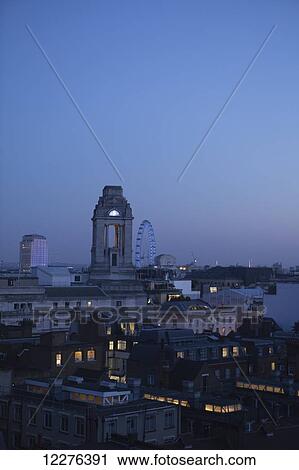 Stock Image - Rooftops of Covent Garden seen from Newton Street, with the London Eye and the Freemasons' Hall; London, England. Fotosearch