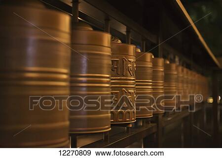 Row of spinning prayer wheels at night, one is stopped; Kyoto, Japan View Large Photo Image Stock Photo - Row of spinning prayer wheels at night, one is stopped; Kyoto, Japan. Fotosearch
