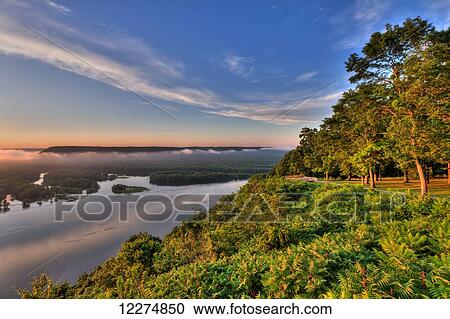 Stock Image - Scenic view of the Mississippi River at sunrise from the viewing platform at Pikes Peak State Park, near McGregor; Iowa, United States of America. Fotosearch