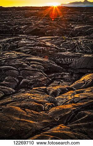 Stock Image - Setting sun light on lava field, Hawaii Volcanoes National Park; Island of Hawaii, Hawaii, United States of America. Fotosearch