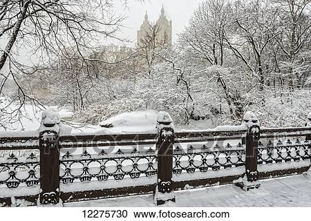 Stock Image - Snow-covered landscape from Oak Bridge, Central Park; New York City, New York, United States of America. Fotosearch
