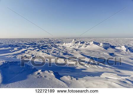 Stock Photo - Snow drifts covering sea ice pressure ridges at Point Barrow, Arctic Alaska, in winter; Barrow, Alaska, United States of America. Fotosearch