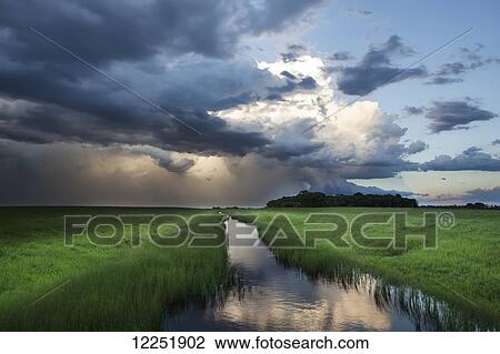 Stock Image - Storm clouds at sunset, near Winnipeg; Manitoba, Canada. Fotosearch