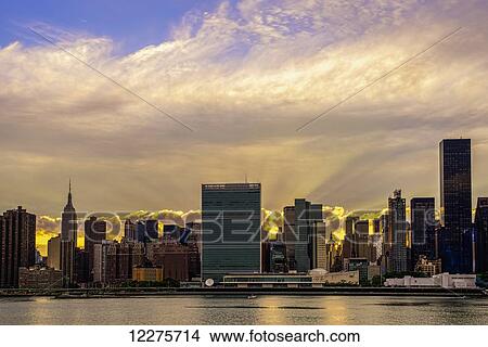 Sun setting behind United Nations; New York City, New York, United States of America View Large Photo Image Picture - Sun setting behind United Nations; New York City, New York, United States of America. Fotosearch