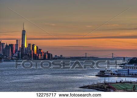 Sunset over Lower Manhattan and the Verrazano-Narrows Bridge; Weehawken, New Jersey, United States of America View Large Photo Image Stock Photo - Sunset over Lower Manhattan and the Verrazano-Narrows Bridge; Weehawken, New Jersey, United States of America. Fotosearch