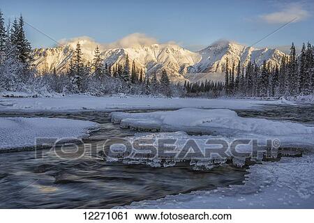 Stock Image - Sunset over the Wheaton River as the light hits Grey Ridge, near Whitehorse; Yukon, Canada. Fotosearch