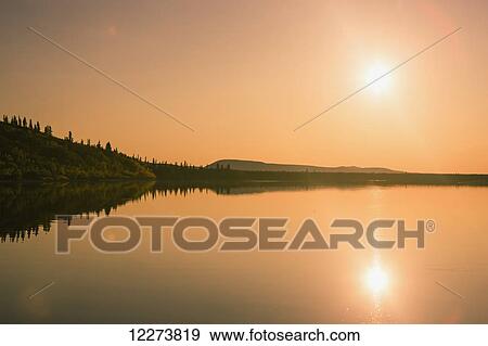 Stock Photo - Sunset reflected over the calm waters of the Noatak River; Noatak, Alaska, United States of America. Fotosearch