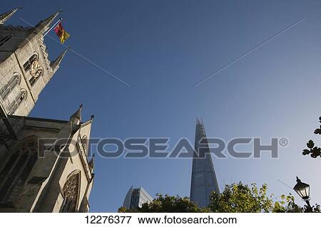 The Shard skyscraper by Renzo Piano rising behind Southwark Cathedral; London, England View Large Photo Image Stock Photo - The Shard skyscraper by Renzo Piano rising behind Southwark Cathedral; London, England. Fotosearch
