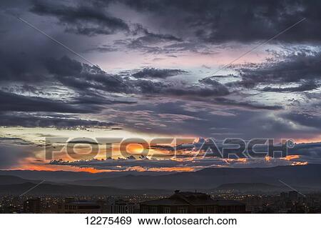 Stock Photo - The sunset colours the skies above the city of Cochabamba; Cochabamba, Bolivia. Fotosearch
