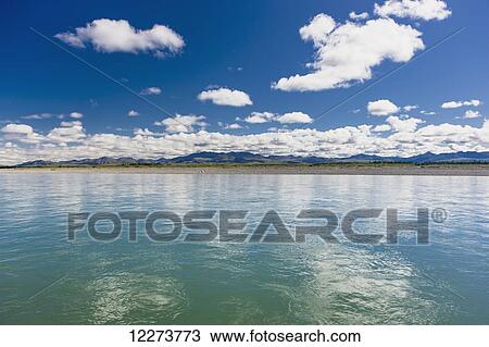 The tranquil waters of the Noatak River reflect clouds in the sky, with the shoreline and mountains in the background; Noatak, Alaska, United States of America View Large Photo Image Stock Image - The tranquil waters of the Noatak River reflect clouds in the sky, with the shoreline and mountains in the background; Noatak, Alaska, United States of America. Fotosearch