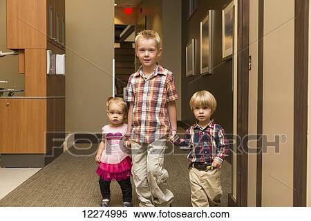 Three young children holding hands and walking down hallway in family dental clinic; Edmonton, Alberta, Canada View Large Photo Image Stock Photography - Three young children holding hands and walking down hallway in family dental clinic; Edmonton, Alberta, Canada. Fotosearch