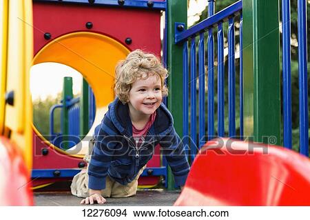 Toddler boy playing at a city playground at sunset; St. Albert, Alberta, Canada View Large Photo Image Picture - Toddler boy playing at a city playground at sunset; St. Albert, Alberta, Canada. Fotosearch