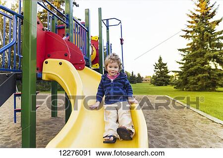Toddler boy playing at a city playground at sunset; St. Albert, Alberta, Canada View Large Photo Image Stock Image - Toddler boy playing at a city playground at sunset; St. Albert, Alberta, Canada. Fotosearch
