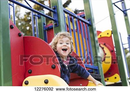 Toddler boy playing at a city playground at sunset; St. Albert, Alberta, Canada View Large Photo Image Stock Image - Toddler boy playing at a city playground at sunset; St. Albert, Alberta, Canada. Fotosearch