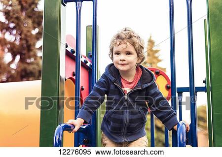 Toddler boy playing at a city playground at sunset; St. Albert, Alberta, Canada View Large Photo Image Stock Photography - Toddler boy playing at a city playground at sunset; St. Albert, Alberta, Canada. Fotosearch