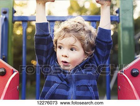 Stock Image - Toddler playing at the playground; St. Albert, Alberta, Canada. Fotosearch