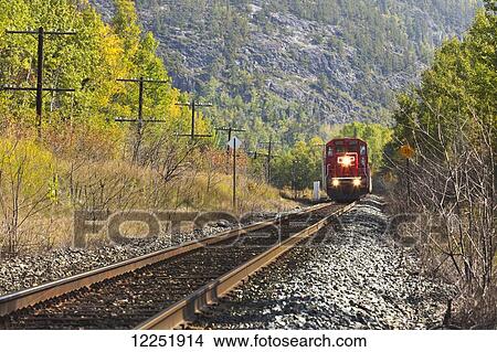 Picture - Train on the tracks in autumn; Wawa, Ontario, Canada. Fotosearch