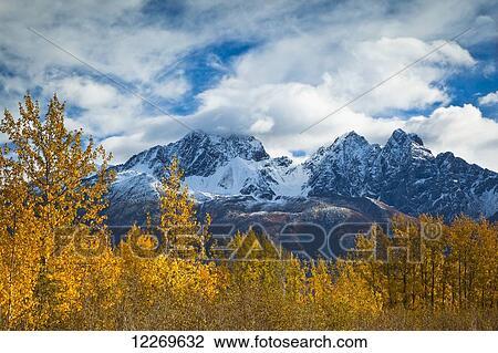 Stock Image - Twin Peaks and Matanuska River meadow, surrounded by autumn coloured birch trees, Palmer Hay Flats State Game Refuge; Alaska, United State of America. Fotosearch