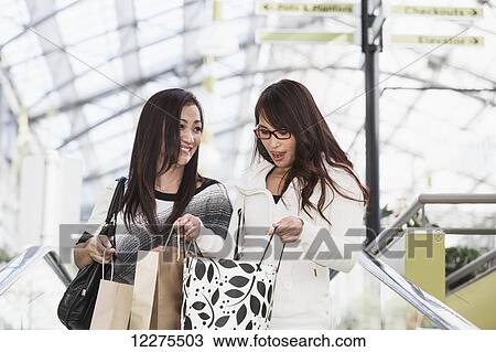 Two girlfriends out shopping together at a shopping mall; St. Albert, Alberta, Canada View Large Photo Image Stock Image - Two girlfriends out shopping together at a shopping mall; St. Albert, Alberta, Canada. Fotosearch