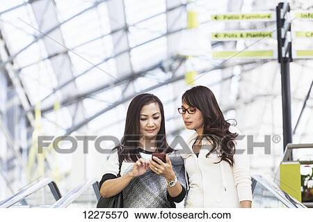 Two girlfriends out shopping together in a shopping mall; St. Albert, Alberta, Canada View Large Photo Image Stock Image - Two girlfriends out shopping together in a shopping mall; St. Albert, Alberta, Canada. Fotosearch