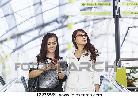 Two girlfriends out shopping together in a shopping mall; St. Albert, Alberta, Canada View Large Photo Image Stock Photo - Two girlfriends out shopping together in a shopping mall; St. Albert, Alberta, Canada. Fotosearch