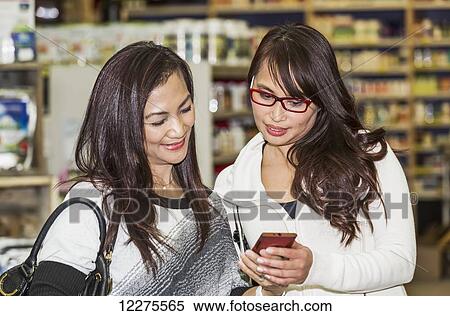 Two girlfriends out shopping together in a shopping mall; St. Albert, Alberta, Canada View Large Photo Image Stock Photography - Two girlfriends out shopping together in a shopping mall; St. Albert, Alberta, Canada. Fotosearch
