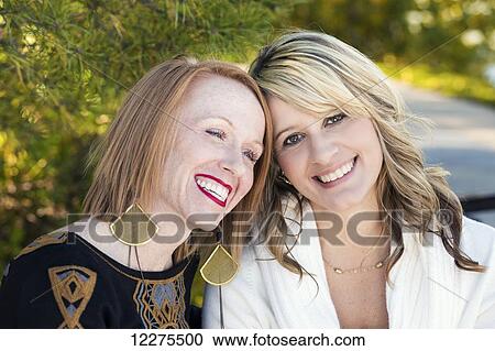 Two girlfriends spending quality time together in a city park in autumn; Edmonton, Alberta, Canada View Large Photo Image Stock Image - Two girlfriends spending quality time together in a city park in autumn; Edmonton, Alberta, Canada. Fotosearch