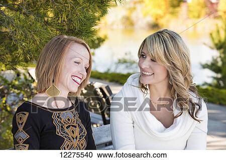 Two girlfriends spending quality time together in a city park in autumn; Edmonton, Alberta, Canada View Large Photo Image Stock Image - Two girlfriends spending quality time together in a city park in autumn; Edmonton, Alberta, Canada. Fotosearch