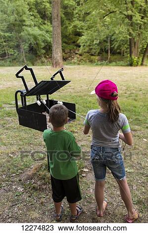 Two kids roasting marshmallows at Bixby State Preserve, near Edgewood; Iowa, United States of America View Large Photo Image Stock Image - Two kids roasting marshmallows at Bixby State Preserve, near Edgewood; Iowa, United States of America. Fotosearch