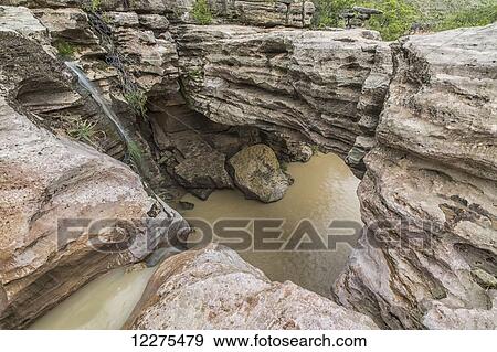 Stock Photo - Uniquely carved rocks and a natural bridge around an unnamed waterfall, Toro Toro National Park; Bolivia. Fotosearch