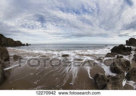 View of the rocky coastline and tide washing up on the sand beach; South Shields, England View Large Photo Image Stock Image - View of the rocky coastline and tide washing up on the sand beach; South Shields, England. Fotosearch