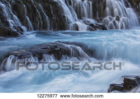 Stock Photo - Water cascading over rocks into a turquoise river; Bruarfoss, Iceland. Fotosearch