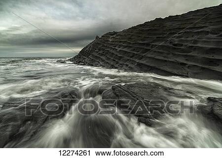 Stock Image - Water rushes over the volcanic bedrock around the area of Tow Hill, Haida Gwaii, Naikoon Provincial Park; Masset, British Columbia, Canada. Fotosearch