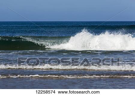 Picture - Waves breaking with blue sky; County Clare, Ireland. Fotosearch