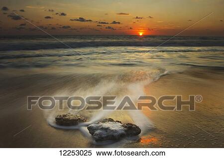 Waves over rocks on the beach at sunset; Mazatlan, Mexico View Large Photo Image Stock Photography - Waves over rocks on the beach at sunset; Mazatlan, Mexico. Fotosearch