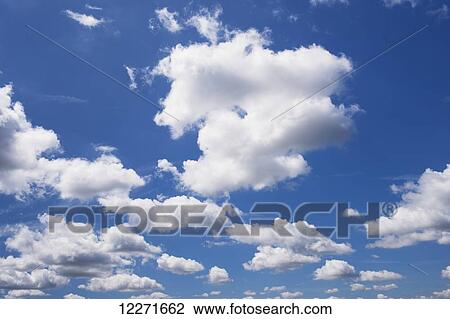 Stock Image - White cumulus clouds in a blue sky; United Kingdom. Fotosearch