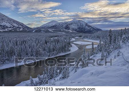 Stock Image - Winter late afternoon light over the Takini River and the mountains in the Southern Yukon; Yukon, Canada. Fotosearch
