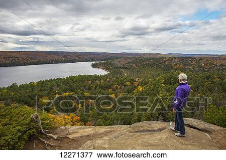 Stock Photo - Woman looking out over Rock Lake from atop Booth's Rock, Algonquin Park; Ontario, Canada. Fotosearch