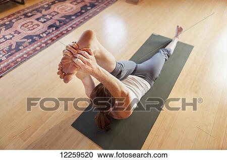 Stock Image - Woman practices yoga at indoor studio, Homer, Alaska. Fotosearch