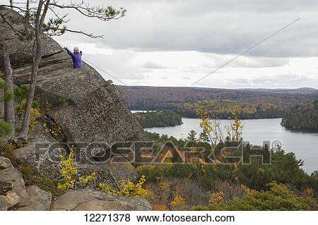 Woman standing with her arms outstretched atop Booth's Rock in Algonquin Park; Ontario, Canada View Large Photo Image Stock Photo - Woman standing with her arms outstretched atop Booth's Rock in Algonquin Park; Ontario, Canada. Fotosearch