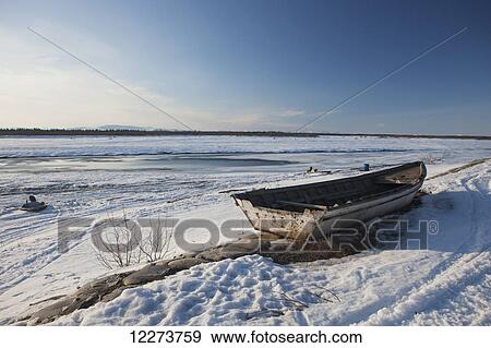 Wooden boat on the bank of the frozen Noatak River in winter; Noatak, Alaska, United States of America View Large Photo Image Stock Photo - Wooden boat on the bank of the frozen Noatak River in winter; Noatak, Alaska, United States of America. Fotosearch