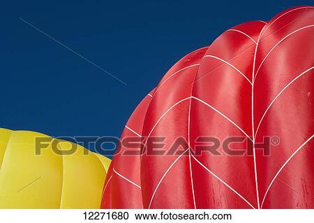 Yellow and a red hot air balloons lift up into the sky as they fill with hot air and prepare for lift-off; Filzmoos, Austria View Large Photo Image Stock Image - Yellow and a red hot air balloons lift up into the sky as they fill with hot air and prepare for lift-off; Filzmoos, Austria. Fotosearch